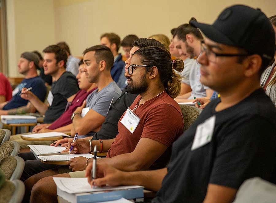 students taking notes in a lecture hall