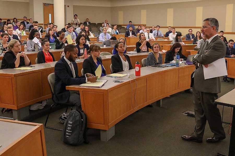 A judge addresses a classroom of law students.