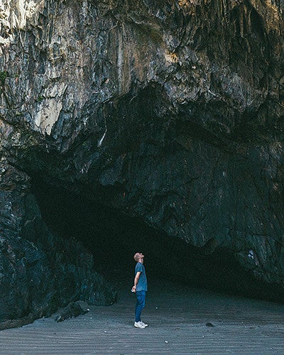 A man standing in a cave looking up