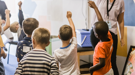 children in a class with little racial diversity raising their hands to be called on