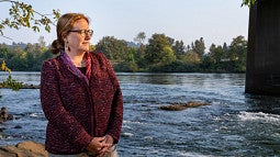 Professor Adell Amos stands next to Willamette River