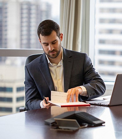 Man in a suit flips a legal pad