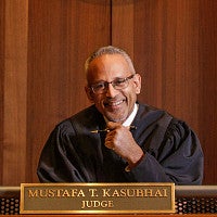 Judge Mustafa T. Kasubhai in the courtroom.