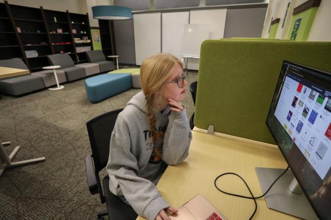 Student using monitor in casual seating area.