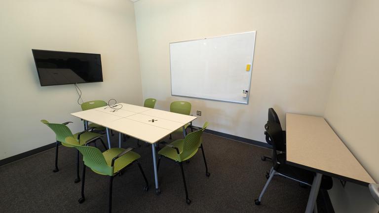 Study room with tables, chairs, TV screen on wall, whiteboard