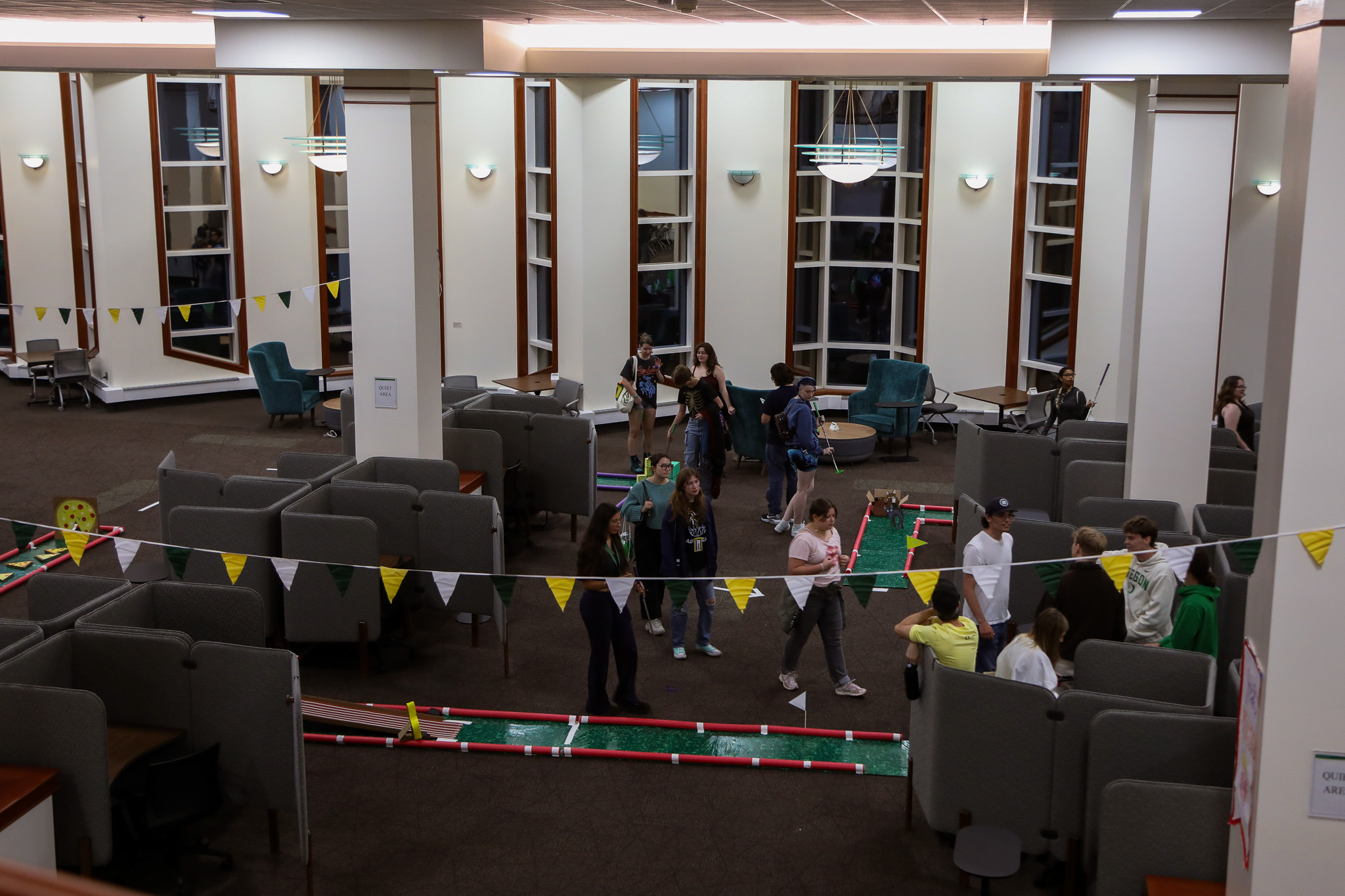 Overhead view of students playing the mini-golf course set up in Knight Library.
