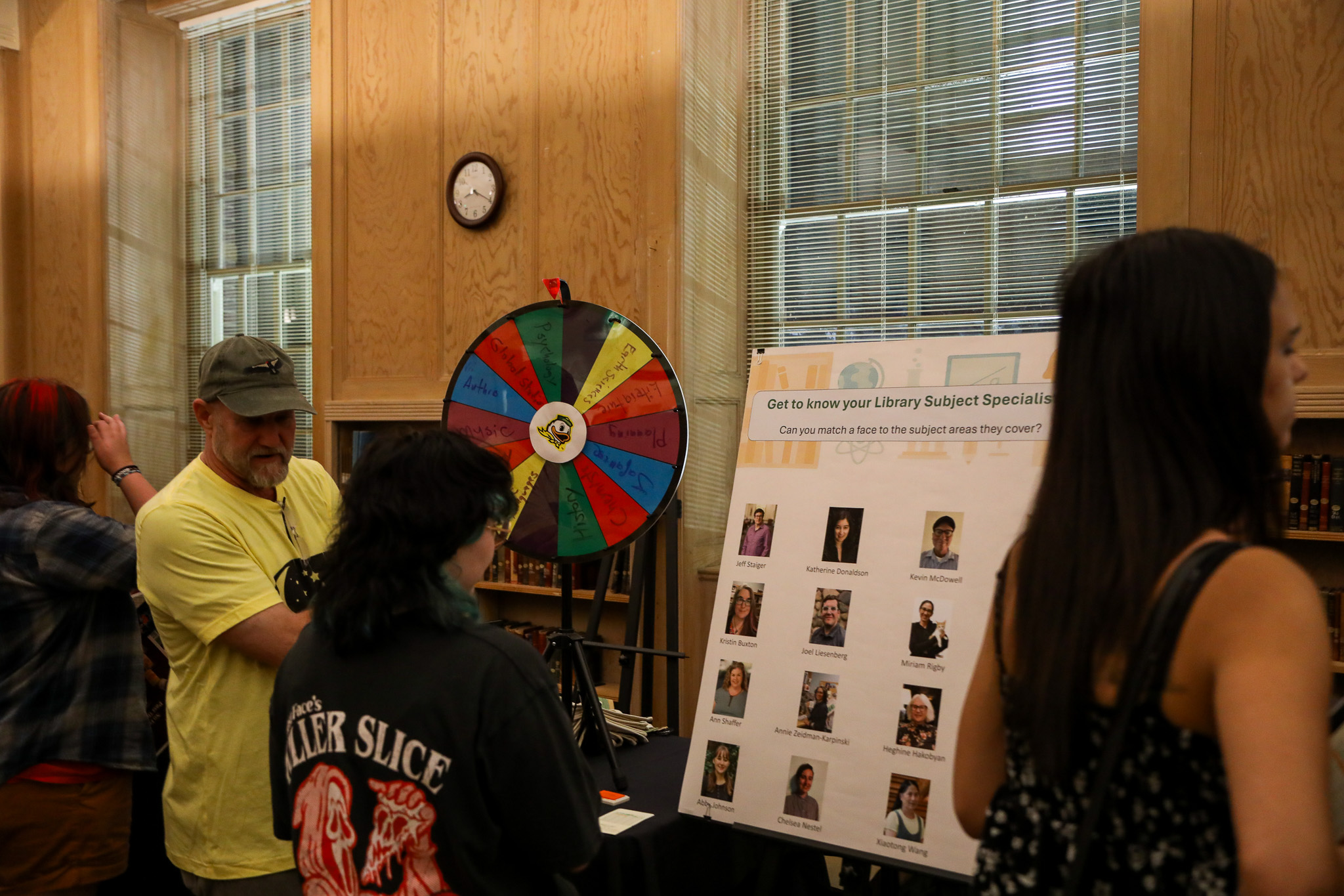 Student examining a poster with pictures of subject specialist librarians.