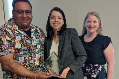 Gerard Sandoval (left), Alicia Salaz (center), and Evey Lennon (right) celebrate Salaz's recognition