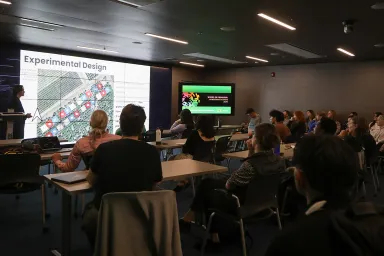 The audience listens as Michael Gehrig presents his research in the Visualization Lab of the Price Science Library.