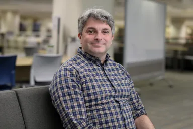 Cameron Mulder sitting on a sofa in Data Services area of Knight Library