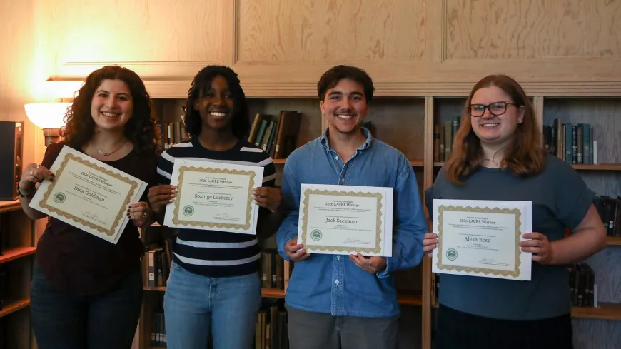 four students hold award certificates 