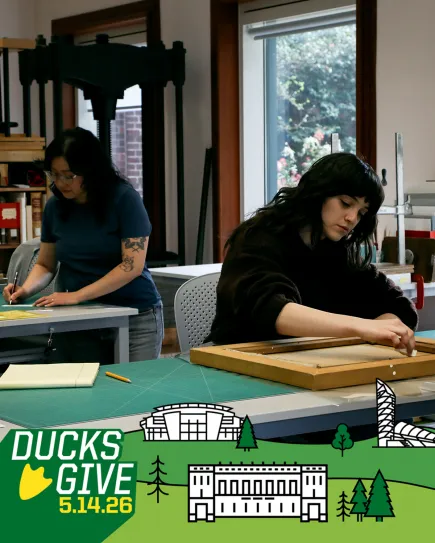 Student worker cleaning the back on a canvas painting on a bench in the Beach Conservation Lab