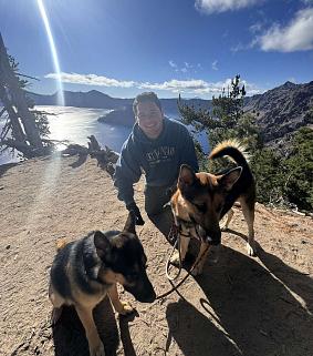 Isaac Wilfong and two shepherd dogs on a trail at Crater Lake National Park.