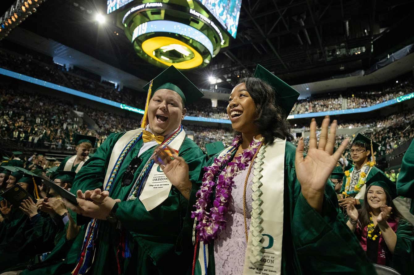 Two graduates singing during the commencement ceremony