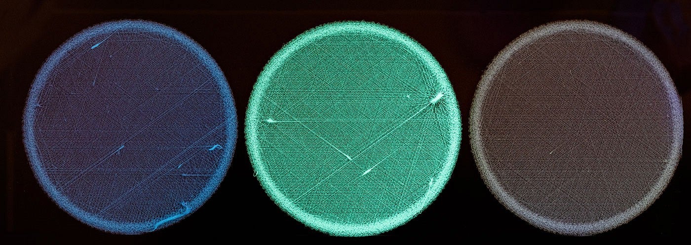 Three disks glowing different colors next to each other on a black background