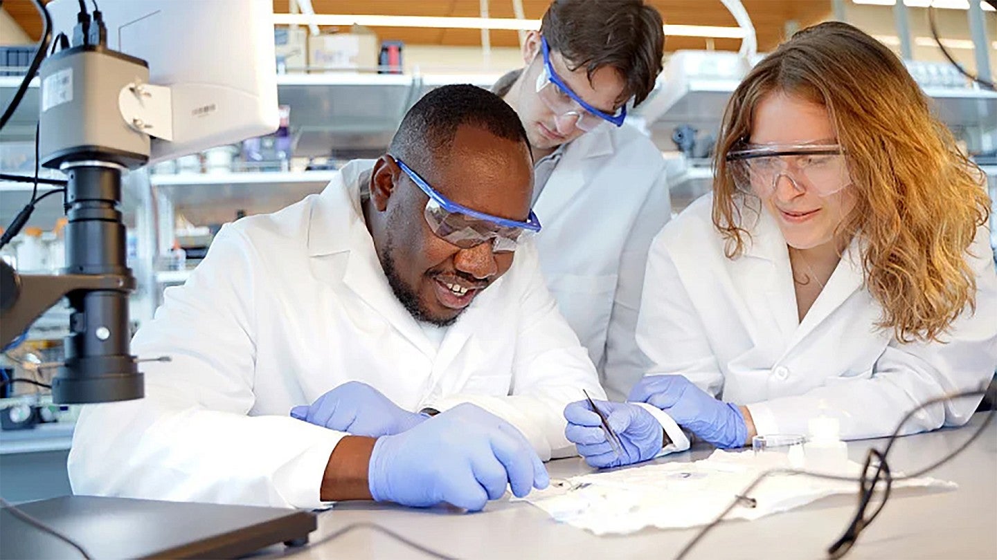 Professor Felix Deku working with students in a lab