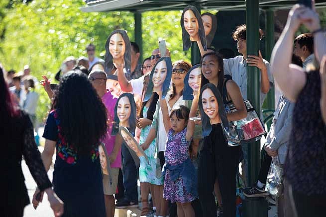Friends and family holding cardboard cutouts of a graduate's face