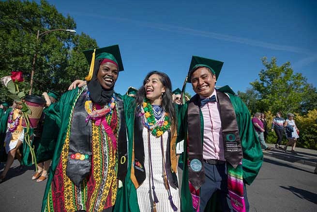 Three graduatres celebrating during the Duck Grad Parade