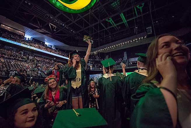 Student waves to the crowd looking for family members