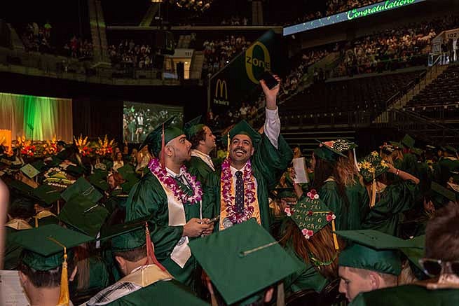 Student waves to the crowd looking for family members