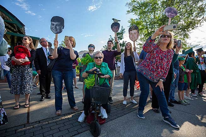 Families cheer along the sidewalk as their students get ready to graduate in Matt Knight Arena