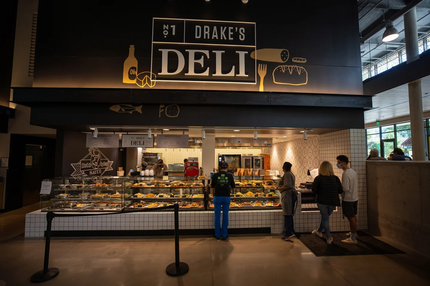 Customers at counter of Drake's Deli in Unthank Hall