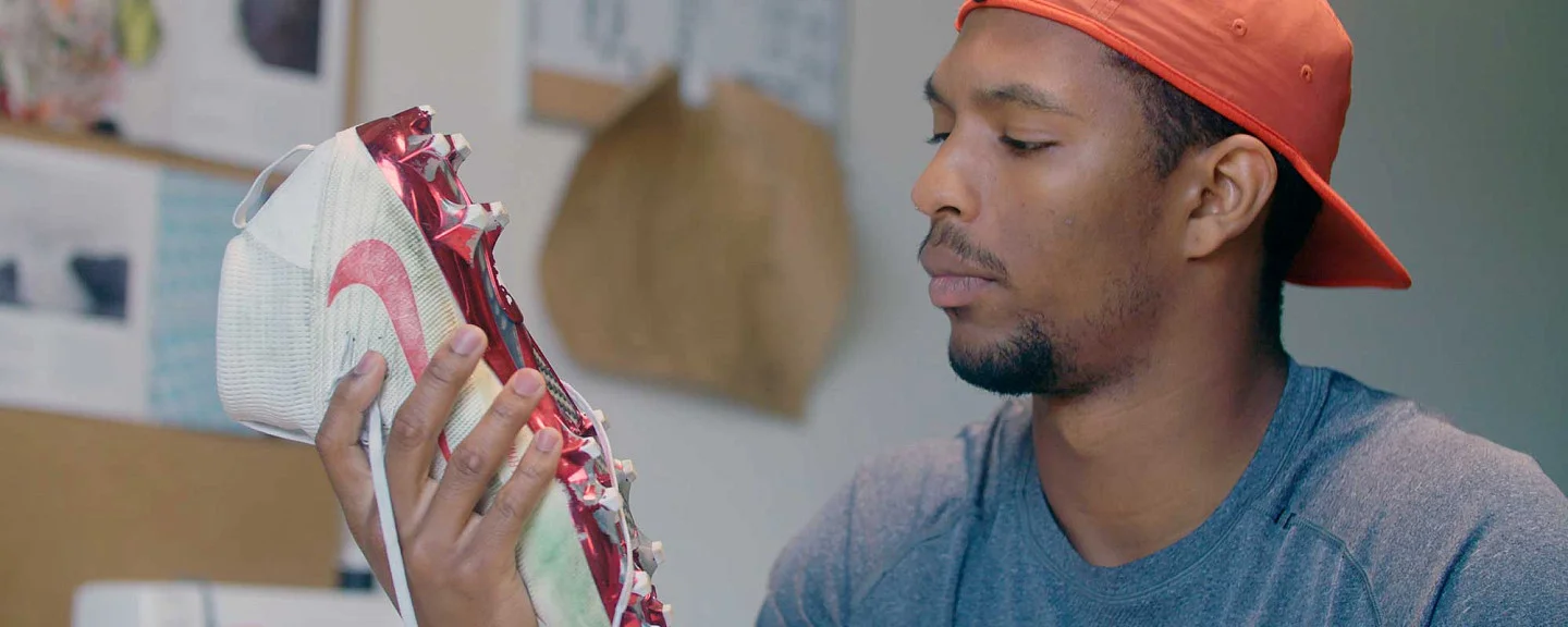 Kodi Whitfield looking at the spikes on the bottom of football cleats
