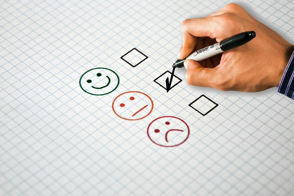 person's hand checking boxes on questionnaire form