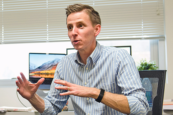 Seth Lewis gestures to a student while seated in his office