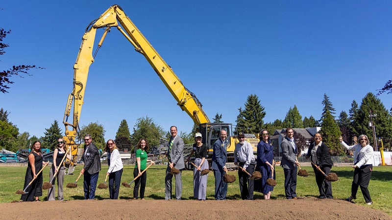 A group of people with shovels ceremonially breaking ground