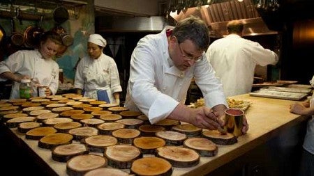 Chef Matt Bennett prepares the "plates" for the duck fat-braised cipollini onion skewers course.