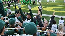 Anna Frazer raises hands in front of the band