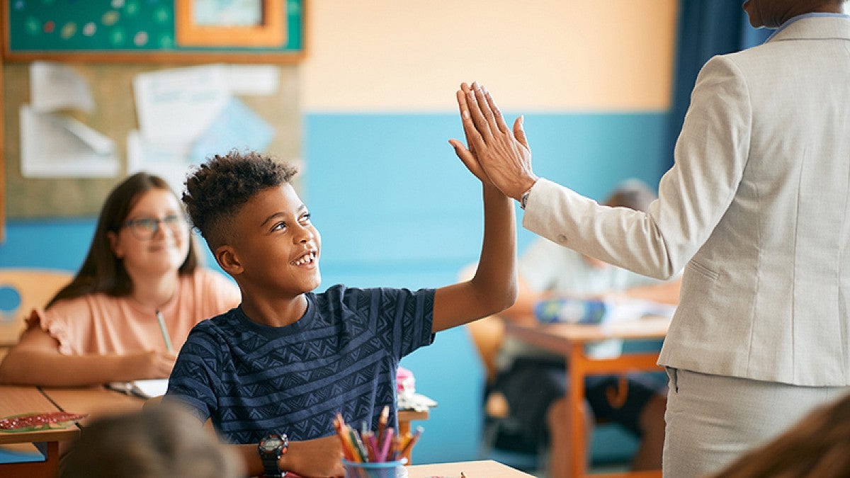 Teacher greeting student in class
