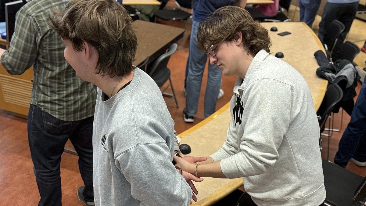 Students conduct mock arrest during a simulated investigation