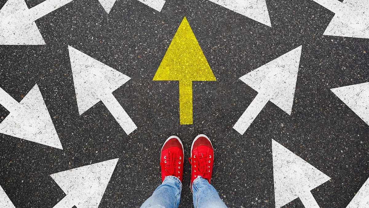 Woman standing on street painted with arrows