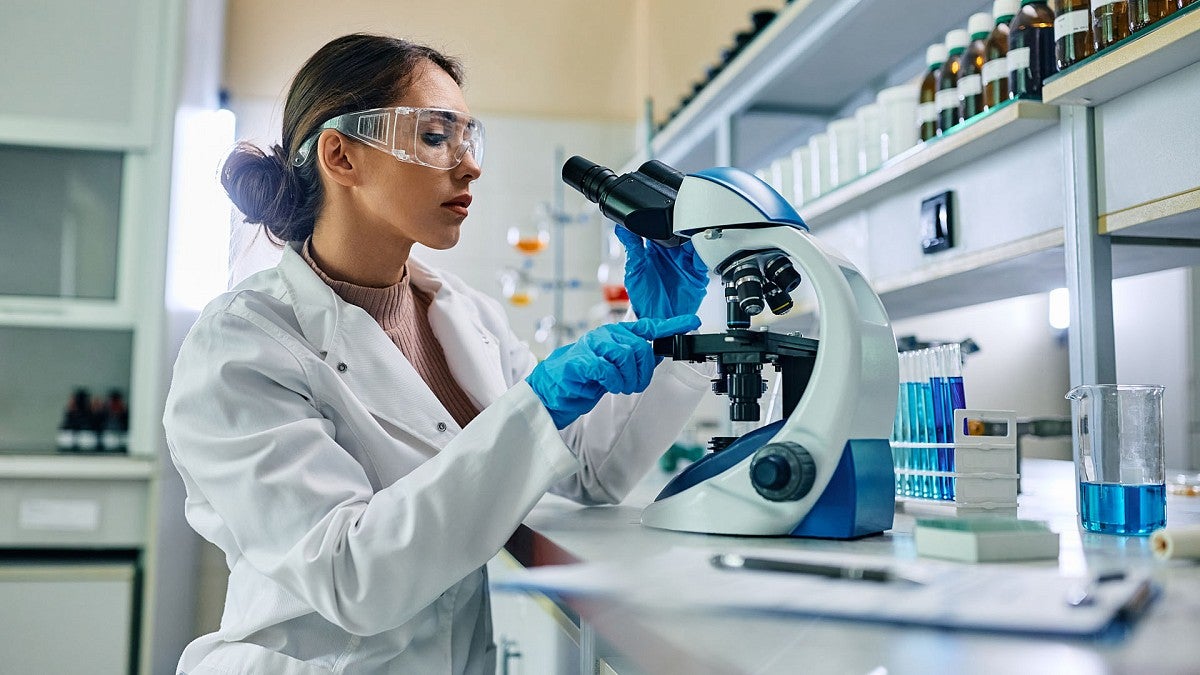 Woman scientist using microscope