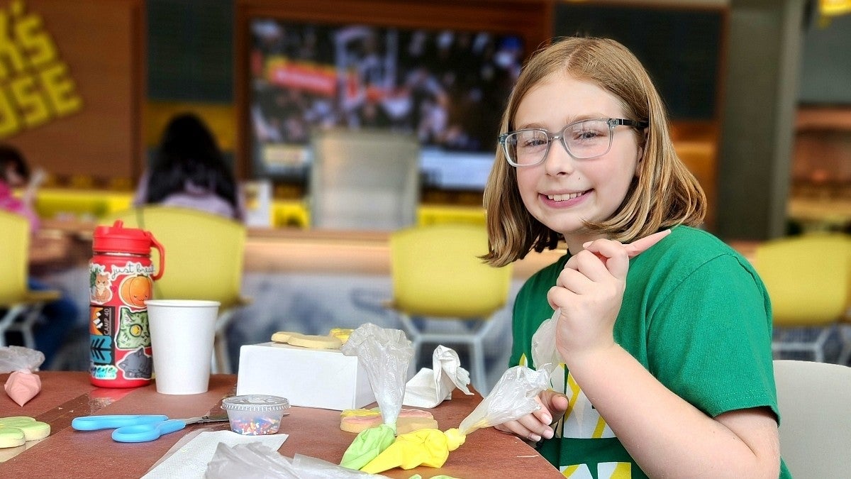 UO Kids on Campus participant frosts Duck cookies