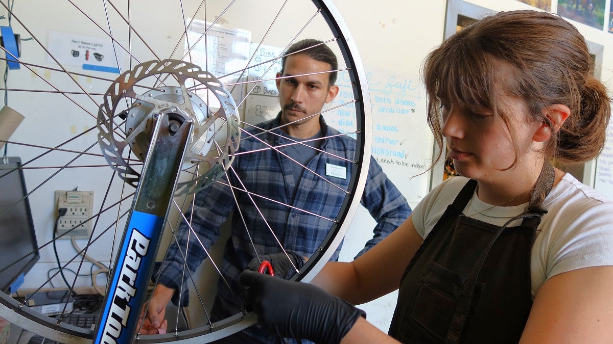 Recent graduate Scout Gesuale (right) learned something new about bike repair every day working as a mechanic with Logan Devack, bike program manager (photo: Matt Cooper)