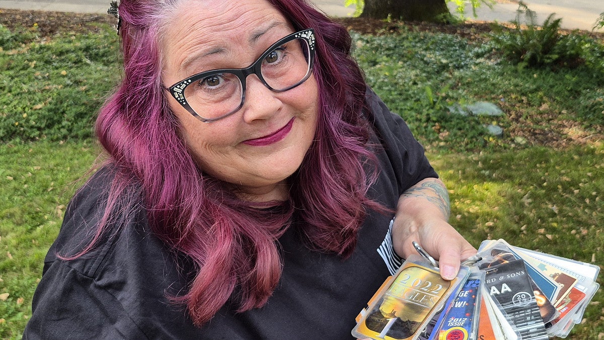 A person holds a handful of backstage passes for rock shows