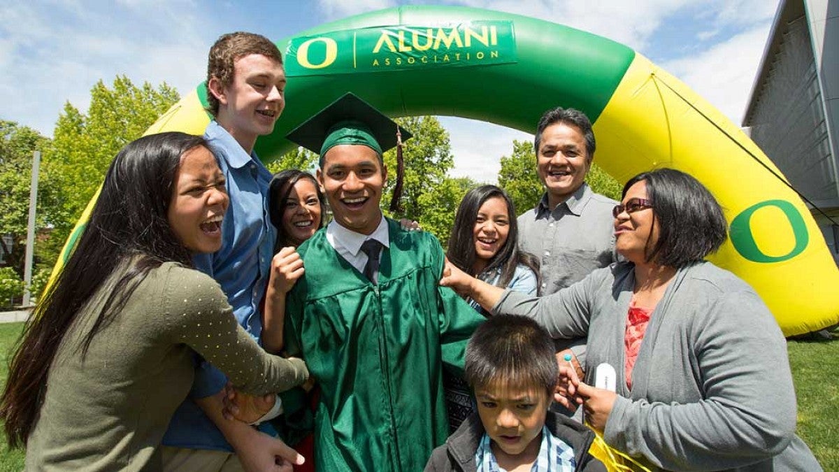 A family celebrating with a graduate in a cap and gown