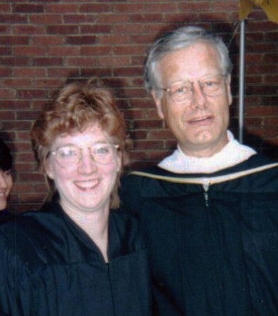 A woman and man in ceremonial academic regalia attend a presidential investiture
