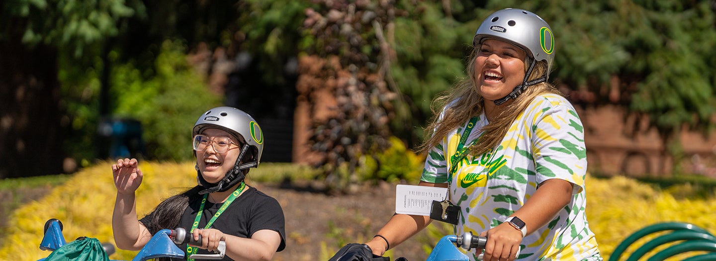 Smiling bicyclists on campus.