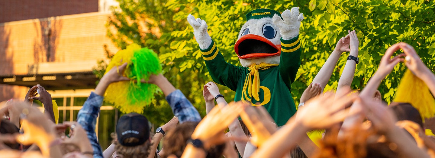 UO Duck in front of crowd with hands up