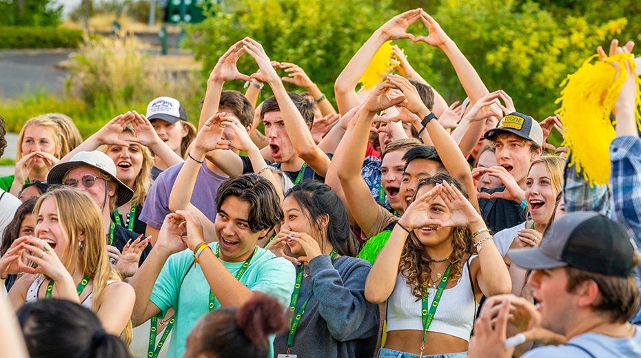 Group of incoming students making UO "O" gesture
