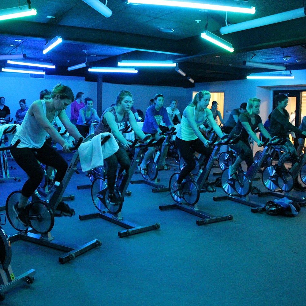 People cycling in spin class.