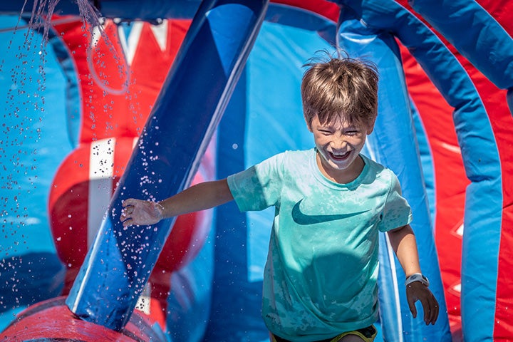Child running on inflatable obstacle course.