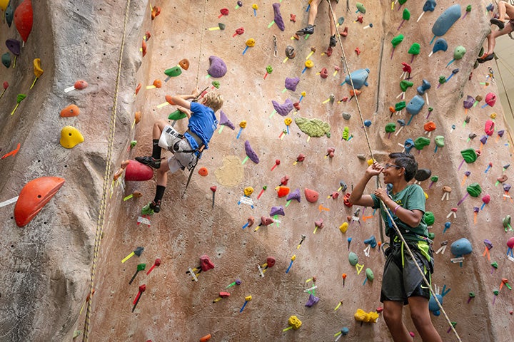 Children rappelling from indoor rock wall.