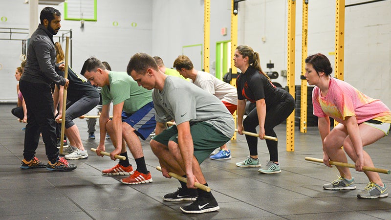 Students working on proper lifting technique in CrossFit class.