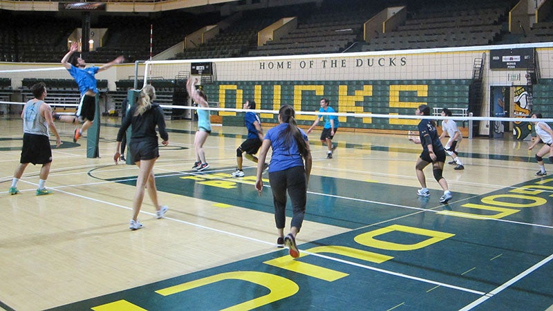 Students playing indoor volleyball.