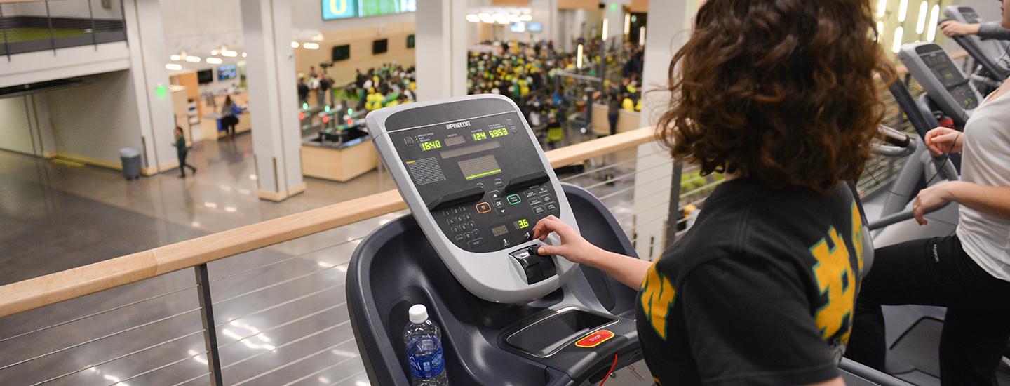 A woman worksout on a treadmill on the Fitness Deck.
